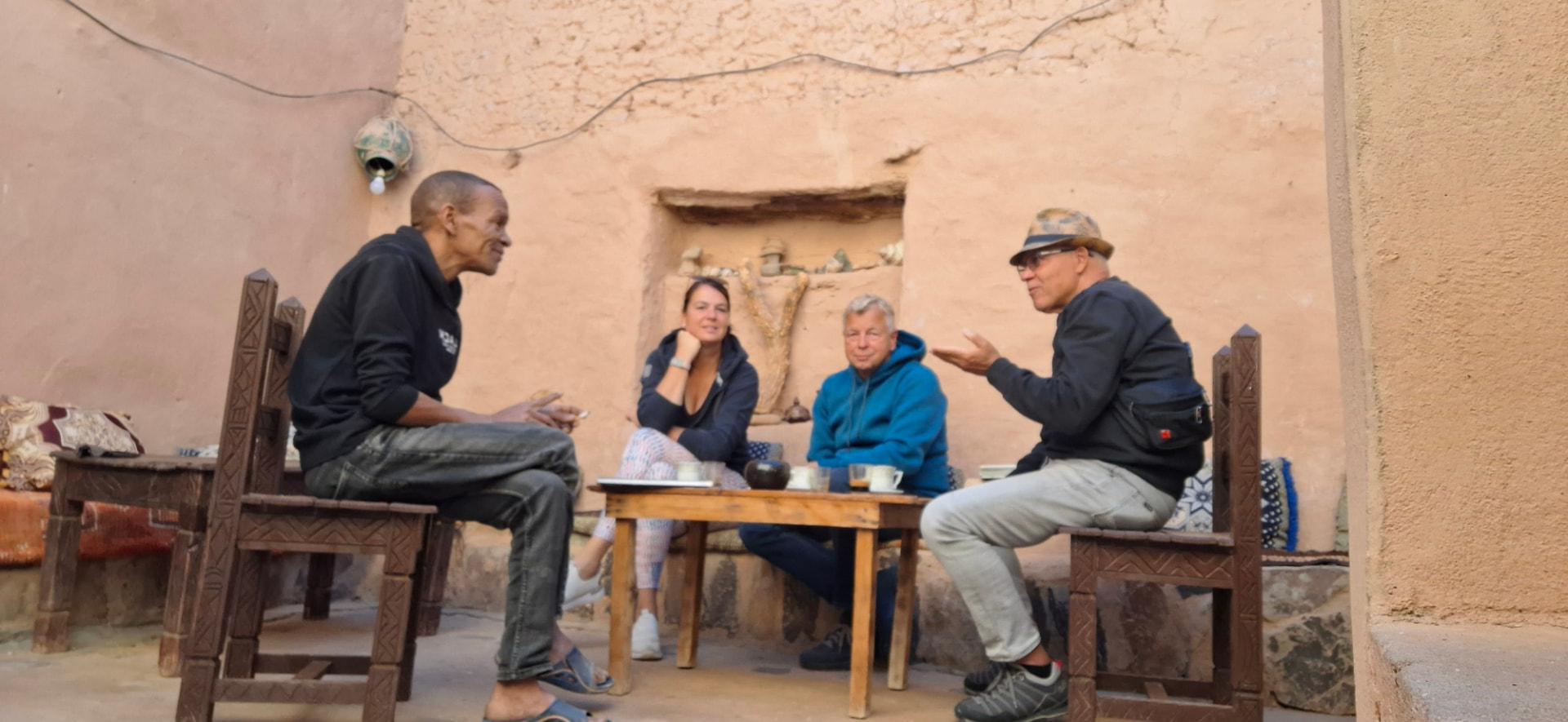 Gäste und Begleiter im Gespräch in einem traditionellen marokkanischen Riad